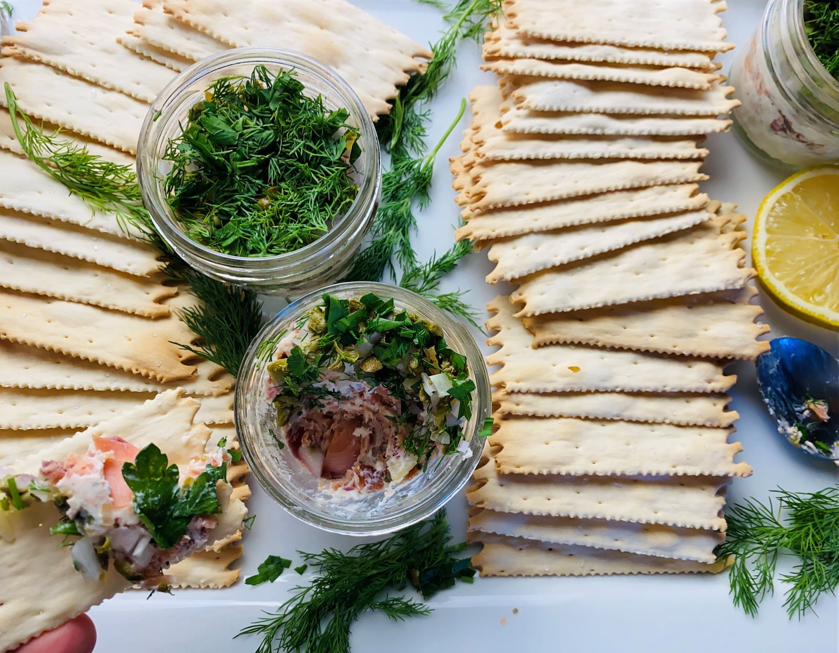 A platter of crackers, lemons, fresh dill and my smoked salmon dip in little mason jars.